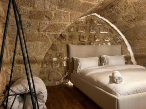 a room with a bed in a stone wall at Arcades 1 de Bahsa in Batroûn