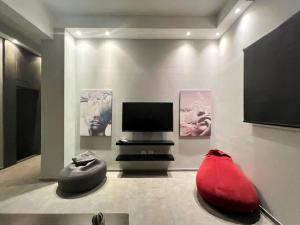 a living room with a tv and a red couch at Nicole 2BR in Gemmayze in Ar Rumayl