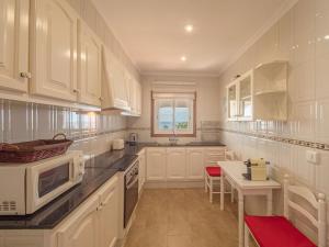 Una cocina grande con gabinetes blancos y una mesa. en Villa Sur, en Binisafua