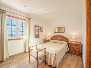 Un dormitorio con una cama y una silla y una ventana. en Villa Sur, en Binisafua 21 fotos más