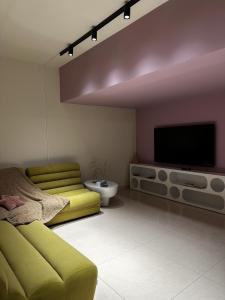 a living room with a couch and a flat screen tv at Bond 3BR Sin El Fil in Beirut