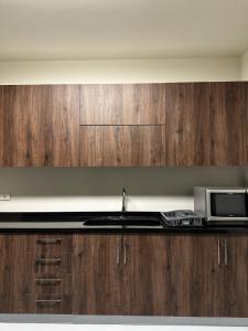 a kitchen with a sink and a microwave at Bond 3BR Sin El Fil in Beirut