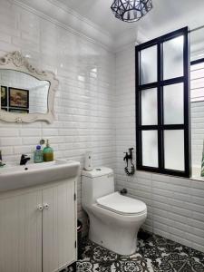 a white bathroom with a toilet and a sink at DRimba 3BR 1-7PX Pool & Near MRT Kota Damansara in Petaling Jaya
