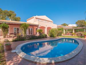 una piscina frente a una casa en Villa Olivia, en Punta Prima