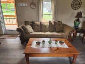 a living room with a couch and a coffee table at Pop's Place -Lakeview 3bd 2 ba on 6 acres in Fort Gibson
