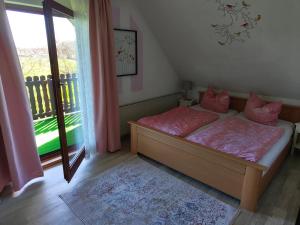 a bedroom with a bed with pink sheets and a window at Aparthotel Schafshorn in Schaprode
