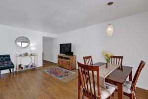 a living room with a dining table and a television at Palm Canyon Villas Escape in Palm Springs