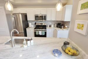una cucina con mobili bianchi e un piano di lavoro di Taylor St Townhouse - Private Parking a Washington