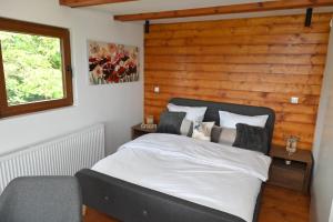 a bedroom with a bed with a wooden wall at Dedovina Pakovraće in Čačak