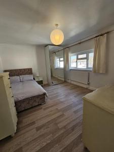 a bedroom with a bed and a large window at The Magical Manor in Leavesden Green