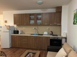 Una cocina con gabinetes de madera y un refrigerador blanco. en Blue Bay Apartments, en Byala 15 fotos más