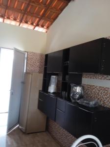 a kitchen with a black counter and a refrigerator at Condominio Nina2 in Icapuí +32 photos