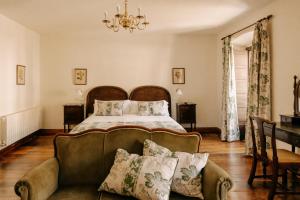 a bedroom with a bed and a couch at Hotel PAX Casona del Busto in Pravia +28 photos