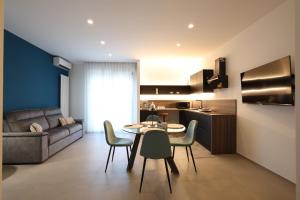 a kitchen and living room with a table and chairs at Pier Boutique Apartment in Mola di Bari