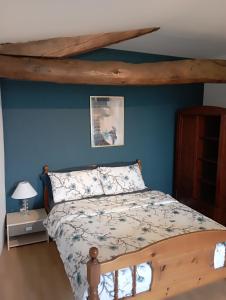 a bedroom with a bed and a blue wall at Le Petit Moulin, Ste Soline in Sainte-Soline +56 photos