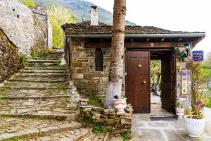 an old stone building with a door and a tree at Shamrock Elati Retreats in Elati