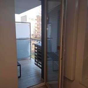 a sliding glass door to a balcony with a view at Apartament Julia 1-4 os Starowapiennikowa 42a z balkonem, klimatyzacją i miejscem parkingowym in Kielce