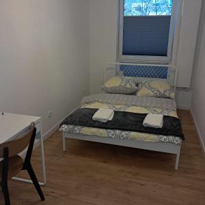 a bedroom with two beds and a desk and a window at Apartament Julia 1-4 os Starowapiennikowa 42a z balkonem, klimatyzacją i miejscem parkingowym in Kielce