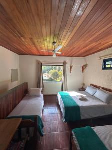 a bedroom with two beds and a wooden ceiling at Fazenda Hotel Alvorada in Santos Dumont +126 photos