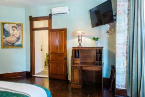 a bedroom with a bed and a dresser and a television at Blue Ridge Abbey Bed and Breakfast in Buena Vista