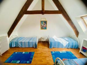 a attic room with two beds and blue mats at La maison du port in Paimpol
