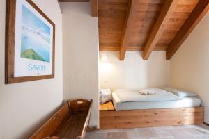 a bedroom with a bed in a room with wooden ceilings at Baita Heidi - Villaggio dei Crodini in Crodo