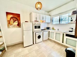 a kitchen with a white refrigerator and a dishwasher at Cosy Triplex in La Marsa in Tunis