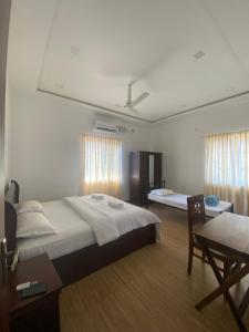 um quarto com uma cama, uma mesa e uma cadeira em Kanasu Serenity em Gokarna mais 15 fotografias