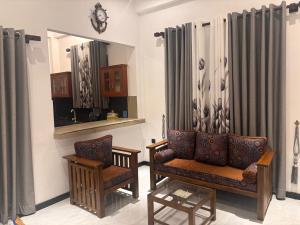 a living room with two chairs and a mirror at Isuru Villa Weligama in Weligama