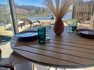 a wooden table with plates and wine glasses on a patio at Aurora Resort in Stasiūnai +18 photos