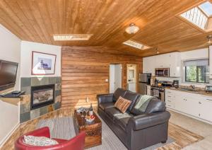 a living room with a leather couch and a kitchen at Cottages at Little River Cove in Little River