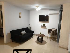 a living room with a black couch and a table at Casa Liseto in Coyula
