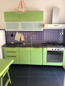 a kitchen with green cabinets and a sink at La casa di Adele in Syracuse