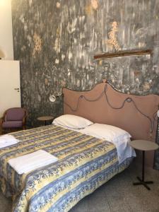 a bedroom with a bed in a room with a wall at La casa di Adele in Syracuse