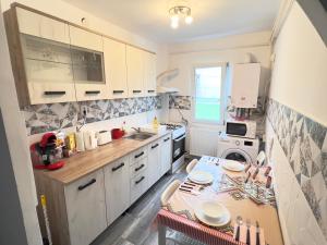 a kitchen with white cabinets and a table in it at Central Garden Palace Iasi in Iaşi