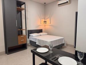 普鲁登特总统城Studios SoHo Bong(II)- studio 3的一间卧室配有床和一张桌子,上面有盘子