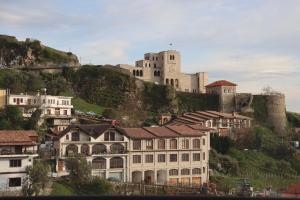 a castle on top of a hill with houses at Pisha Panoramic Rooms in Krujë