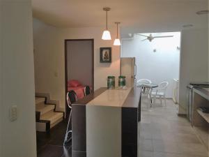 cocina y sala de estar con barra y mesa en Conjunto Buganviles -, en Girardot