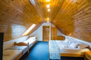 a large room with two beds and a wooden ceiling at Győrfi Apartmanház Zamárdi in Zamárdi