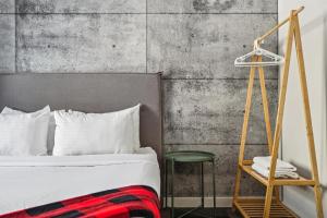 a bedroom with a bed and a green stool at Auberge Manitonga in Mont-Tremblant