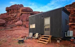 a black tiny house in front of a mountain at Primal Resorts in Allen Memorial Hospital Heliport +16 photos