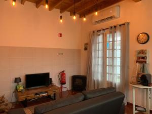 a living room with a couch and a tv at Residência Mariana in Furnas