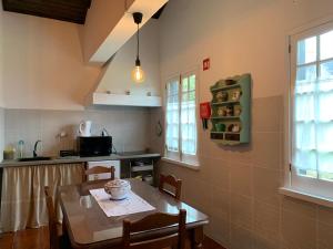 a kitchen with a table and chairs in a room at Residência Mariana in Furnas
