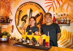a man and a woman standing behind a bar with drinks at Isla - The Island Experience in El Nido