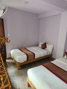 2 letti in una camera con pareti bianche di Hotel sunrise heaven a Pokhara