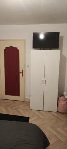 a bedroom with two white cabinets and a red door at F3 plein centre ville de Gien in Gien