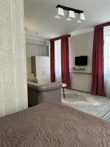 a bedroom with a bed and a living room at SAMAL Hotel in Aksay