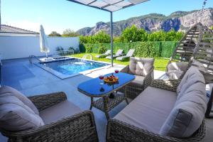 a patio with chairs and a table and a pool at Villa Nature Lux in Ortaca