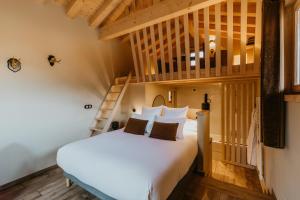 a bedroom with a white bed and a staircase at Hôtel Restaurant La Ferme de Cupelin in Saint-Gervais-les-Bains