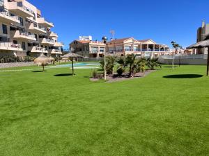 een groen gazon voor een gebouw bij La Zenia12 in Orihuela